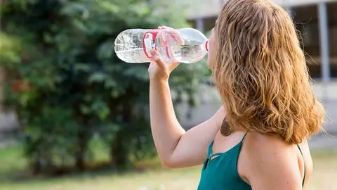 Mujer bebiendo agua calor ola